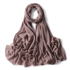 Dettaglio hijab in chiffon oro lucido, tessuto drappeggiato morbido, sciarpa elegante.