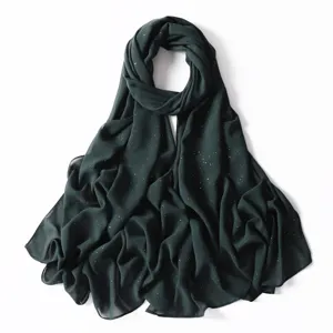 Dettaglio sciarpa in chiffon glitter verde scuro, elegante hijab brillante e scialle leggero.
