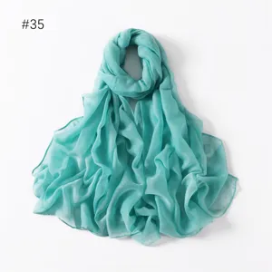 Turquoise lightweight solid color long scarf detail view, elegant drape and soft fabric texture.