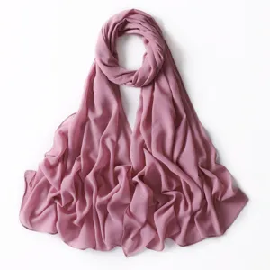 Vista dettagliata dell'elegante sciarpa hijab in chiffon rosa antico con riflessi dorati.
