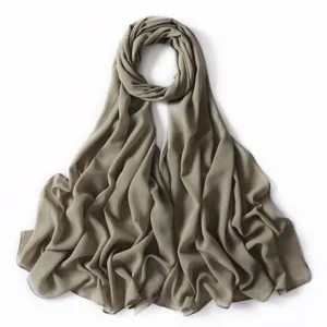 Vista dettagliata di una sciarpa lunga in chiffon perlato tinta unita con delicati punti oro, verde.