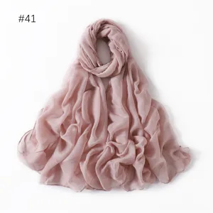 Close-up detail of soft solid color pink scarf fabric, lightweight drape texture background.