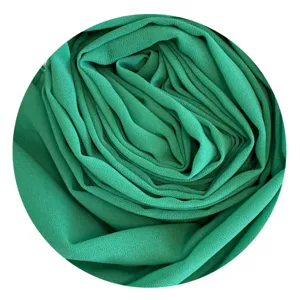 Close-up detail of solid green chiffon hijab fabric, showing soft texture and draped folds.