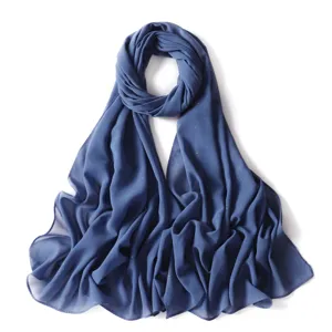 Dettaglio dell'hijab in chiffon blu con motivo a punti dorati scintillanti e consistenza morbida.