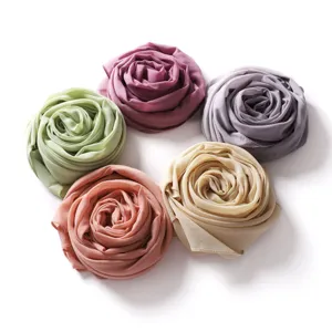 Dettaglio sciarpe hijab in chiffon, arrotolate a forma di rosa con opzioni multicolore.