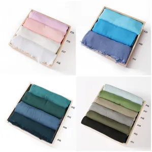 Detail view showcasing a variety of solid color rayon scarves neatly rolled in display trays.