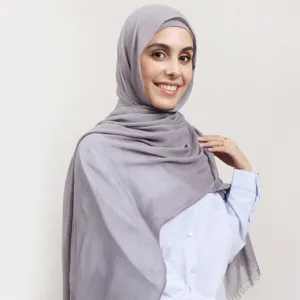 Close-up detail of the gray modal crinkle hijab showing delicate fringe and soft texture.
