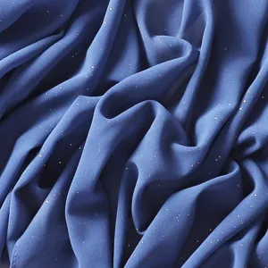 Vista ravvicinata che mostra la texture fine e i punti dorati scintillanti dell'elegante sciarpa blu.