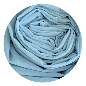Close-up of soft light blue chiffon fabric texture, showing delicate folds and smooth drape.