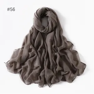 Close-up detail of lightweight solid color grey long scarf, delicate sheer fabric texture for travel.