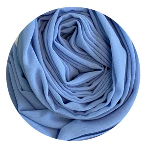Close-up detail of soft chiffon hijab fabric roll showing texture and delicate pleats.