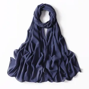 Primo piano dettagliato del foulard hijab in chiffon blu scuro con sottili punti dorati.