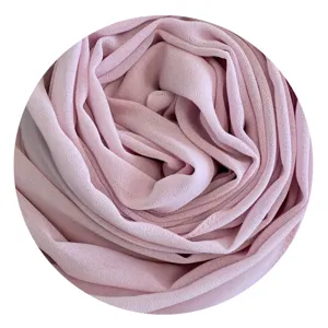 Close-up detail of soft pink chiffon hijab fabric, showing delicate texture and elegant folds.