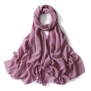 Primo piano dettagliato di foulard hijab in chiffon malva con sottili punti dorati.