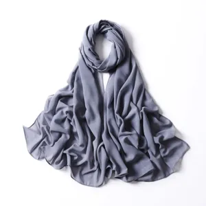 Primo piano del tessuto in chiffon grigio luccicante con sottili puntini dorati e dettagli.