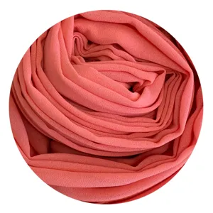 Detailed view of soft chiffon hijab fabric showcasing fine texture and coral pink color.