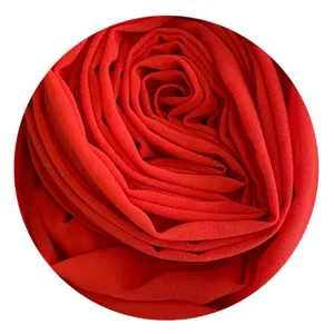 Detailed close-up shot of the soft red chiffon hijab fabric showing its fine texture.