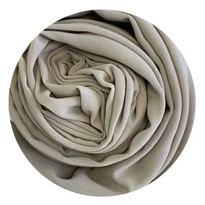 Close-up detail shot of the soft beige chiffon hijab fabric, showing delicate drape and texture.