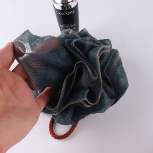 Detailed view of dark blue mesh bath puff, soft shower sponge for daily body cleaning.