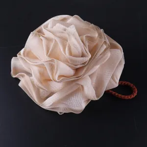 Close-up detail of the elegant champagne rose shower sponge, showcasing its soft mesh texture.