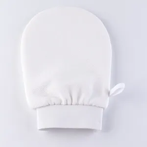 Dettaglio del guanto da bagno esfoliante bianco, materiale scrub spesso, polsino elastico.