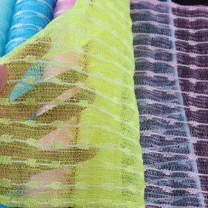 Detailed close-up of colorful exfoliating bath mesh cloth showing textured structure.