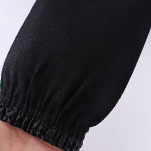 Detailed close-up view of black single-layer exfoliating bath glove with elastic wrist cuff.