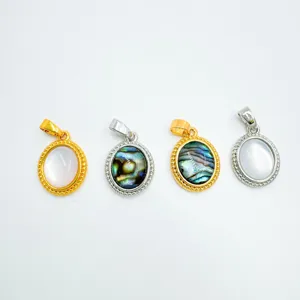 Primer plano detallado de joyas colgantes ovales con concha natural y abulón colorido.
