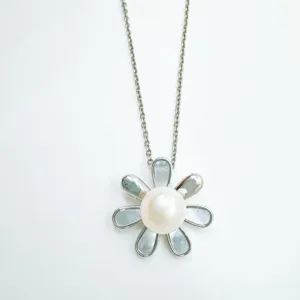 Close-up detail of silver chain necklace with a pearl flower pendant and shimmering petals.