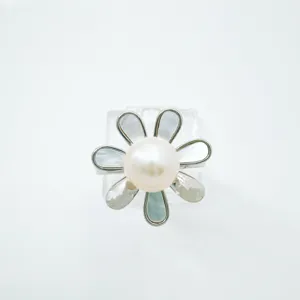 Detailed view of silver tone flower ring accessory featuring white pearl and mother of pearl petals.