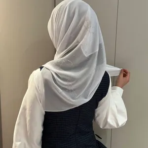 Détail de l'écharpe en mousseline au dos montrant un noeud en strass étincelant et beau tombé.