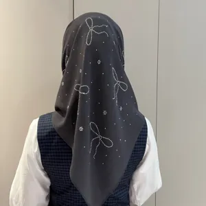 Vue détaillée du foulard en mousseline gris foncé avec des motifs de nœuds en strass.