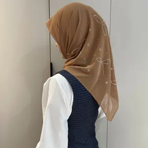 Foulard hijab en mousseline avec strass nœud papillon, détail de coiffe style preppy élégant.