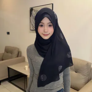 Gedetailleerd overzicht van de zwarte strass-hijab, toont de stofstructuur en wikkelstijl.