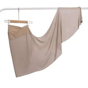 Gedetailleerd overzicht van de elegante khakikleurige chiffon hoofddoek met strass stippen.