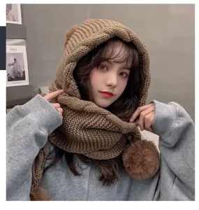 Brown knitted hooded scarf with cute pom-poms, thick warm winter hat detail view.