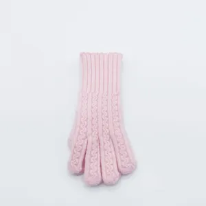 Primer plano de guante de invierno de punto trenzado rosa con textura de lana fina cálida.
