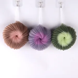 Detailed view of large two-color sunflower bath sponge with hanging string for rich foaming.