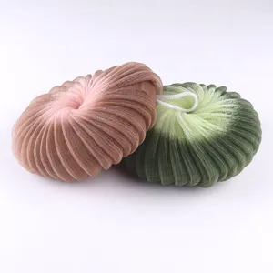 Detailed view of soft mesh bath sponge with two-tone gradient design and hanging loop.