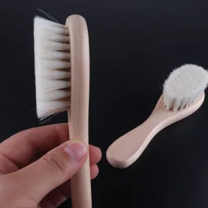 Gros plan de la brosse à cheveux douce en bois pour bébé et brosse visage aux poils naturels.