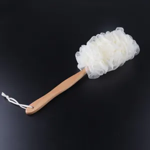 Detalle del mango de madera largo y esponja de baño de red blanca para la limpieza de la espalda.