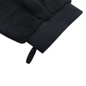 Detalle de guante de baño exfoliante negro de textura gruesa, ideal para el cuidado corporal.