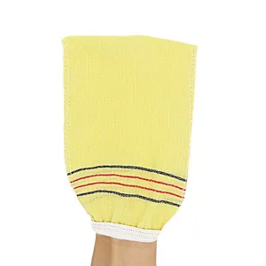 Primer plano detallado del guante de baño exfoliante amarillo con textura rugosa y muñeca elástica.