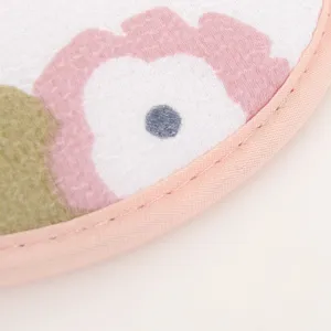 Detailed view of the soft exfoliating bath mitt showing delicate floral pattern and pink edge.