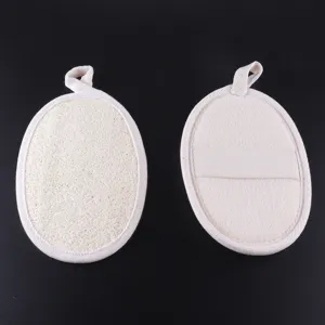 Detailed view of natural loofah bath pad with beige hem and hand strap for exfoliating.