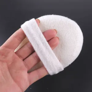 Vue détaillée de l'éponge de bain ronde blanche avec sangle pour une prise en main facile.