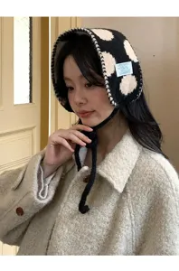 Detalle en primer plano del gorro de punto con estampado de lunares y cálidas orejeras.