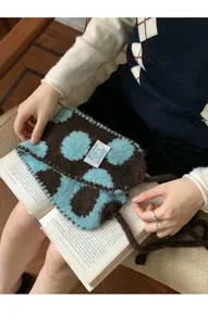 Vista detallada del mini bolso de punto marron y azul con textura suave y correa delicada.