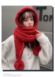 Detailed close-up view of the cozy red knitted hooded scarf with cute plush pom-poms.