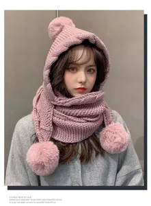 Detailed view of women winter pink knitted hooded scarf with cute pom pom, warm thick earflap.